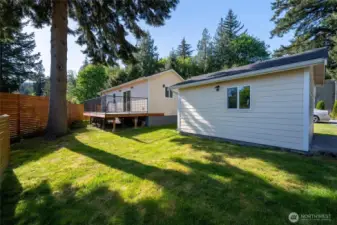 Looking at the privately situated home and shop with the evergreens beyond.
