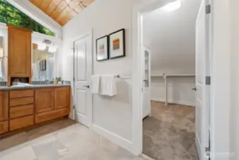 Beyond the double vanity, two separate doors lead to the toilet with door for privacy and spacious walk-in closets—each offering personalized organization potential.