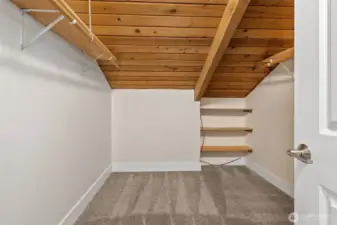 Rustic charm meets utility in this second walk-in closet, complete with built-in shelving.