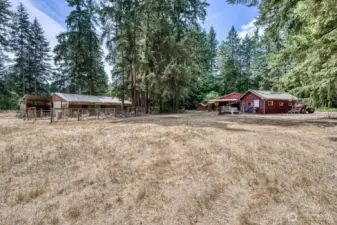 The view of the barn, one car garage and house.