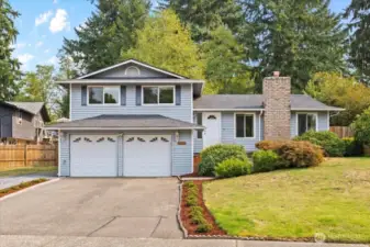 Charming curb appeal on a private corner lot with greenbelt backdrop.