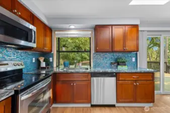 Kitchen features beautiful tile backsplash, granite counters, and stainless steel appliances.