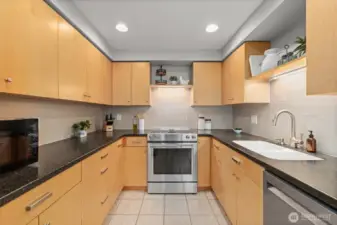 The stainless steel appliances complement the sleek cabinets. Notice the large sink and backsplash tile.