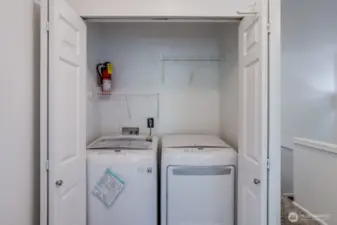 Laundry closet with digital appliances and storage conveniently located near bedrooms.