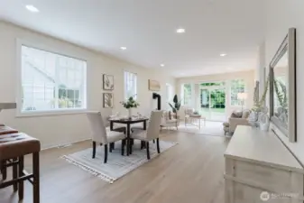 Filled with natural light, the living room offers a warm and welcoming atmosphere with a cozy gas fireplace as its centerpiece. Two large windows flank the sliding glass door, perfectly framing the peaceful view of the backyard and providing easy access to the back patio.