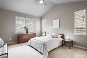 Spacious and serene primary suite with abundant natural light, plush flooring, and an ideal retreat for rest and relaxation.