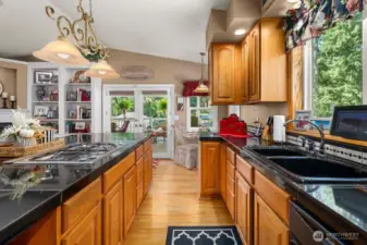 Spacious kitchen with plenty of counter space and cabinets is located right off the covered deck, a perfect place to entertain.