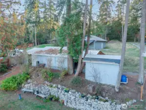 Looking toward Griffith Point Rd, behind the house sits two detached shops, wood storage (left) and well house.