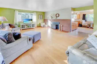 Cozy and open living room with wood burning fireplace and ample natural light flows in from large windows. Flow into the kitchen effortless with the open floorplan.