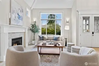 Front living room with gas fireplace, elegant millwork, and abundant natural light.