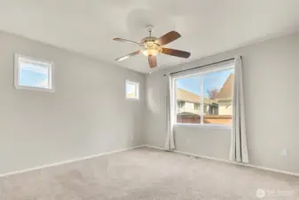 Light Filled Primary Bedroom with Dual-Wall Windows Creating a Bright, Inviting Retreat, Complete with a Ceiling Fan