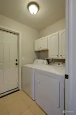 Down the hall, the first room we come to is the laundry room, which also leads to the garage.