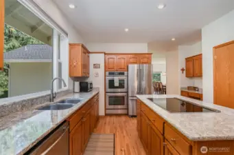 The kitchen boasts warm cabinetry, an open layout, recessed lighting, stainless steel appliances and a spacious walk-in pantry—combining style and functionality for the perfect culinary space.