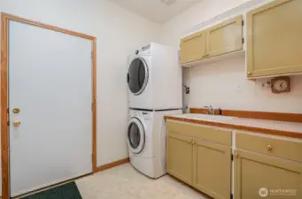 Spacious laundry room equipped with a sink and abundant storage, providing a functional and organized space for all your laundry needs.