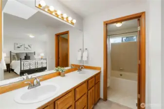 Primary with dual sinks. Walk-in closet is to the left and a privacy door for toilet and shower/tub combo.