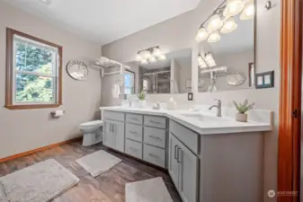 Primary suite bathroom with lots of drawers and cabinets. Double sinks and lots of lighting.