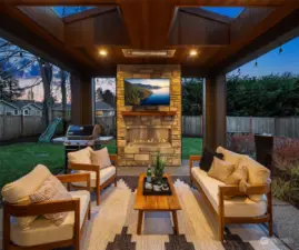 Covered outdoor living space complete with fireplace and built-in heaters