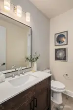 Main floor powder bath complete with tile accent wall