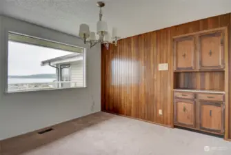 Next to the living room is the formal dining room with wood paneling and a built in wood hutch for your fine china and service ware. While you dine you can take in the views through the large picture window.