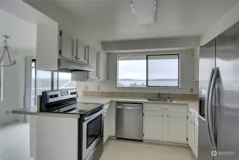 The cook's kitchen is light & bright and features all stainless steel appliances. Next to the kitchen is an additional eating area, plus access to the view deck through the sliding glass door