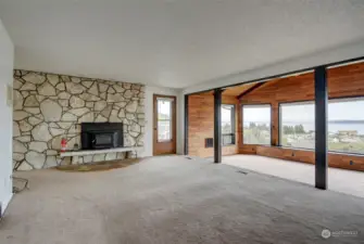 Living room is highlighted by an enormous natural stone fireplace with a wood-burning insert, for the cold nights in the winter. Doorway gives access to large view deck.