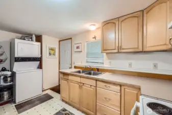This shows entry door to ADU, kitchen, and stackable washer/dryer. Has it's own water heater next to the laundry.