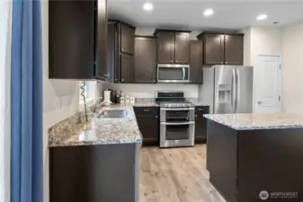 Stunning Dark brown cabinets, generous granite countertops and island!