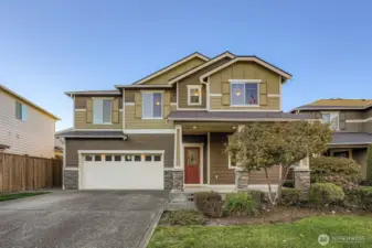 Front exterior with landscaped yard and covered entry.