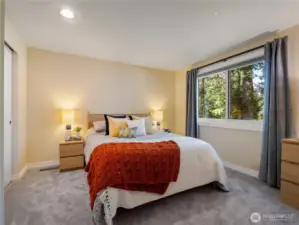 One of the three bedrooms on the second floor. Each with a neutral paint color, wall to wall carpet, and fantastic views of the gardens. The views of the majestic evergreens give this room a feeling of being in a tree-house.