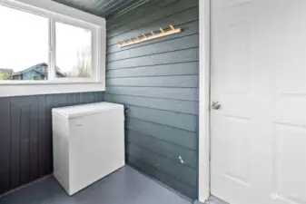 Mud room off the dining nook with chest freezer. This room leads to the backyard.