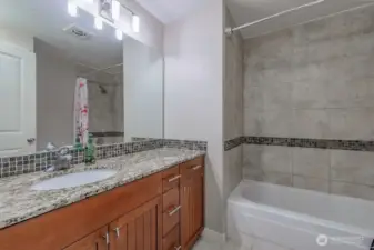 Large bathroom with full tub & shower and linen closet behind the door.