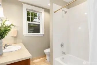 The main floor full bath was updated with travertine tile and slab countertop, new vanity, tub/shower, lighting, and fixtures.  This bath is the hall, just off the main floor bedroom and the living spaces.