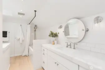 The Primary bath features slab marble counters, a wide vanity with lots of storage space, linen closet, and a skylight for natural light.
