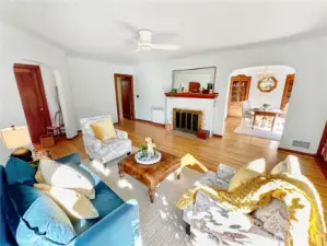 In this view of the living room you see the arched opening to the formal dining room, hall to additional bedrooms and bath and alcove to the front entry.