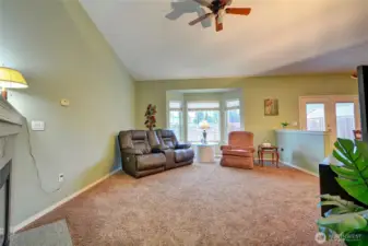 The living room has vaulted ceilings, bay window, cozy gas fireplace and is open to the dining room.