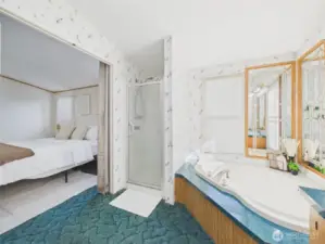 Views of shower, soaking tub into bedroom with closet adjacent
