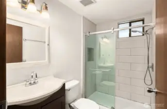Stylishly updated upstairs bathroom featuring a refreshed shower and new ceramic tile flooring.