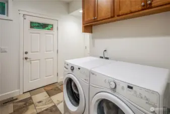 spacious utlity room with laundry access, side door outside and garage enterance.