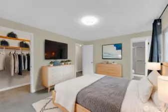 Virtually staged Primary Bedroom Suite features a walk in closet and private bathroom.