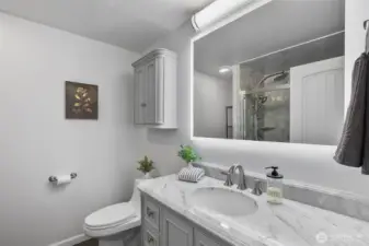 Primary bath features a walk-in shower, LED lighting, fresh paint, and beautiful new cabinetry.