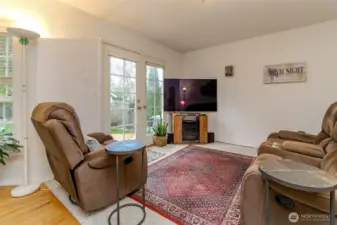 The cozy family room offers French doors leading to the expansive deck