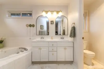 This large five-piece bath features dual sinks and a good sized vanity with ample storage. A generous tub invites luxurious, relaxing soaks, while a walk in shower provides space for daily routines.