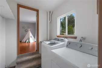 Laundry room off of additional living space, with access to garage.