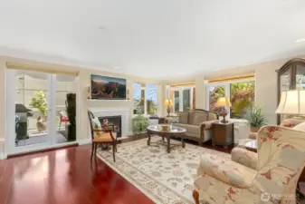 Spacious light filled living room with gas fireplace.