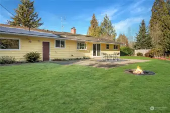 A view of the rear of the home and large patio and firepit for entertaining.