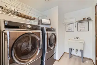 Laundry room with convenient sink and shelving, just off the kitchen.