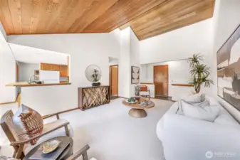 Another view of the living room emphasizes its height and openness, with a modern aesthetic and warm wood tones. An inviting blend of comfort and style defines this central gathering space.