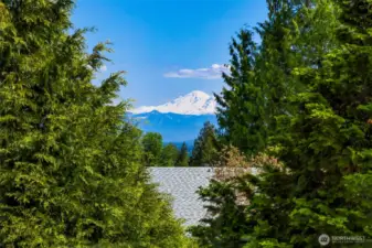 Majestic view of snow-capped Mt. Baker framed by evergreens provides a dramatic visual from the deck and upper-level windows.