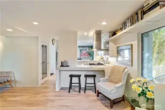 Cozy room off of the kitchen and front entry with custom book shelf, eat-up bar and entry to the deck.