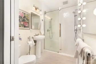 Second bathroom upstairs with spacious shower and natural light via transom windows.